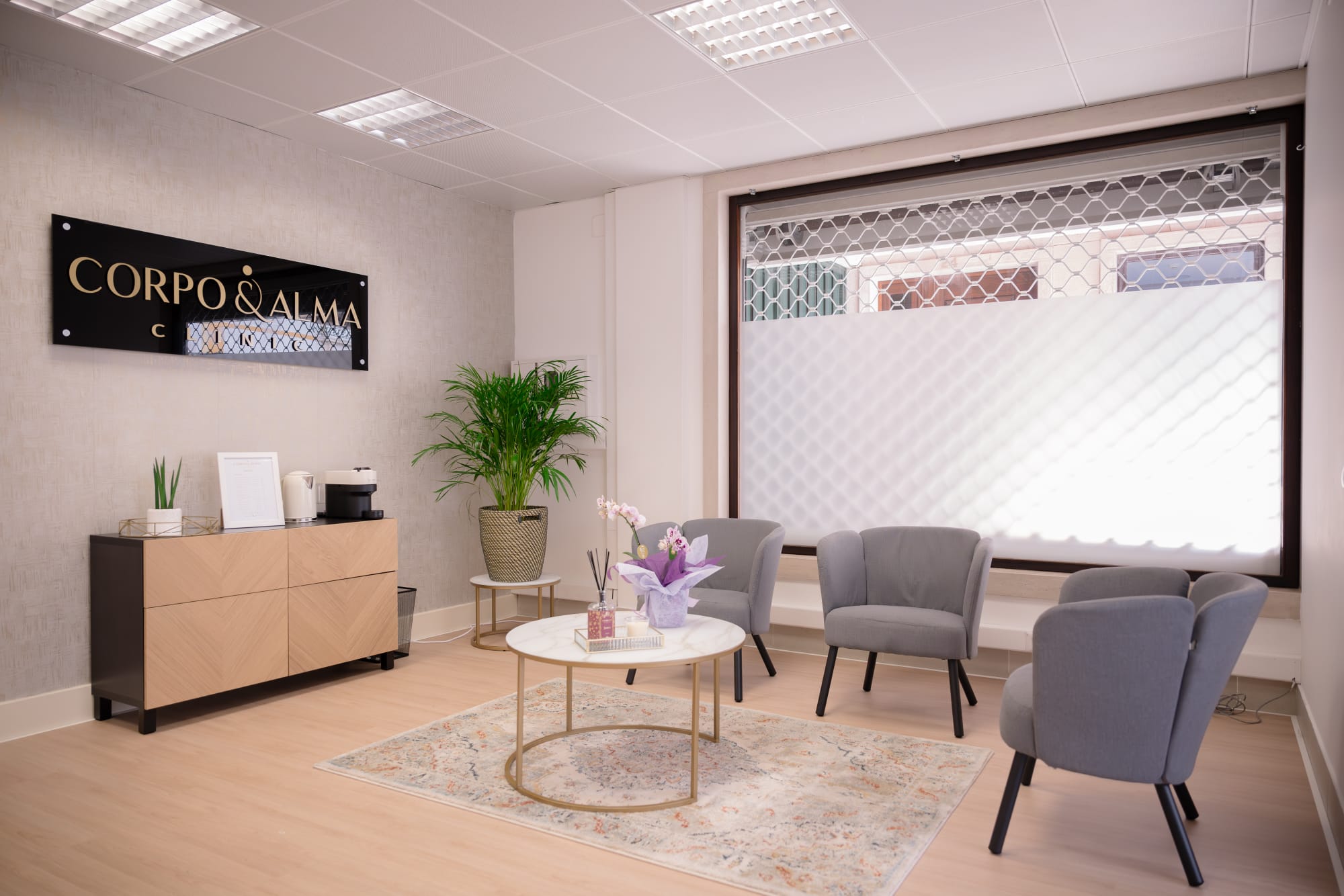 Sala de espera e receção da Corpo & Alma Clinic em Tomar, com luz natural, cadeiras e plantas